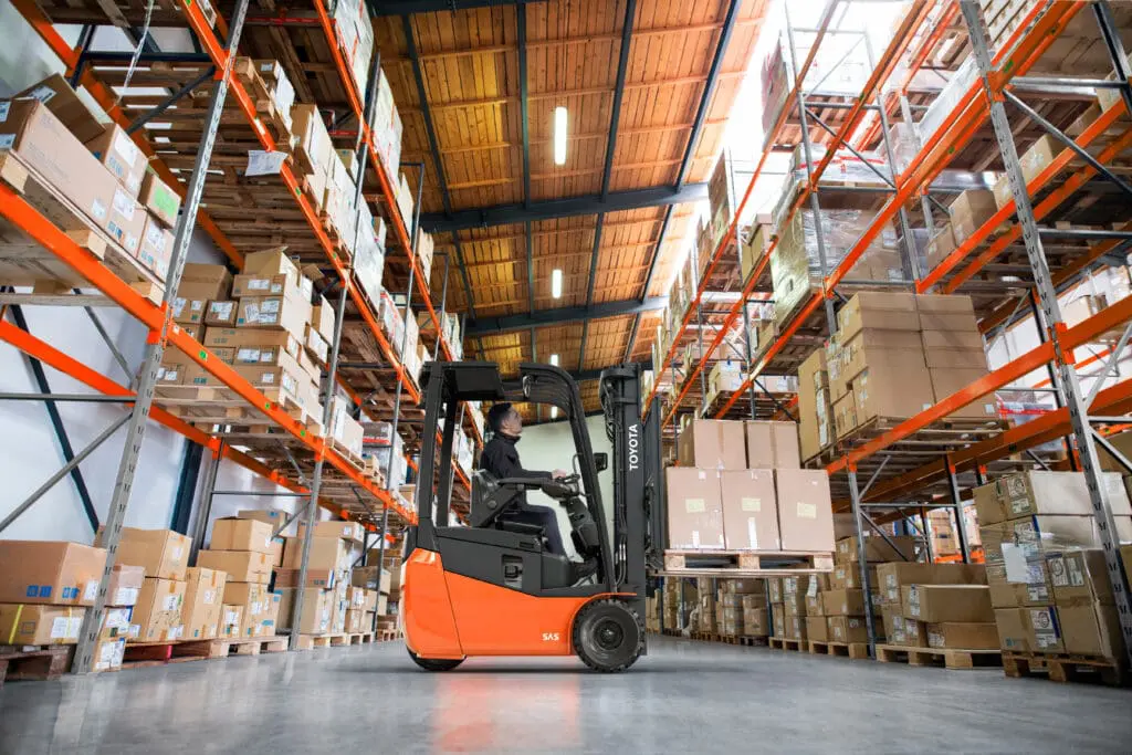 Toyota Traigo 24 elektrische heftruck pallets heffen in magazijn met hoge stellingen | Prins Maasdijk