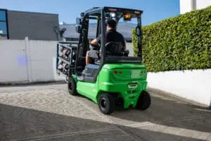 Bestuurder op een groene CESAB B4-20 heftruck die een lading verplaatst over een verharde oprit buiten. — Prins Maasdijk