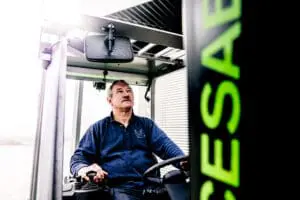 Bestuurder in de cabine van een CESAB heftruck, omhoog kijkend tijdens het bedienen van de machine. — Prins Maasdijk