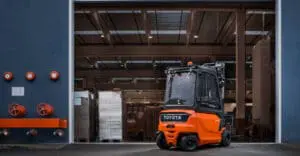 Toyota Traigo 48V 4-wiel elektrische heftruck rijdend bij laaddock van industrieel magazijn | Prins Maasdijk
