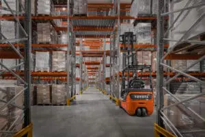 Toyota Traigo 48V 3-wiel elektrische heftruck stapelen van zware industriële containers in magazijn | Prins Maasdijk