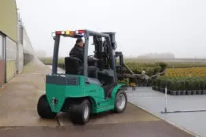 Bestuurder op een groene Prins Panther XL-E Zero Emission heftruck in gebruik op een kwekerij in mistig weer. — Prins Maasdijk