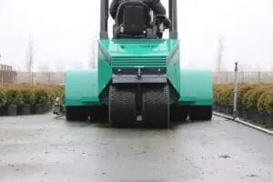 Achteraanzicht van de Prins Tiger XXL-E heftruck rijdend tussen rijen potplanten op een kwekerij. — Prins Maasdijk