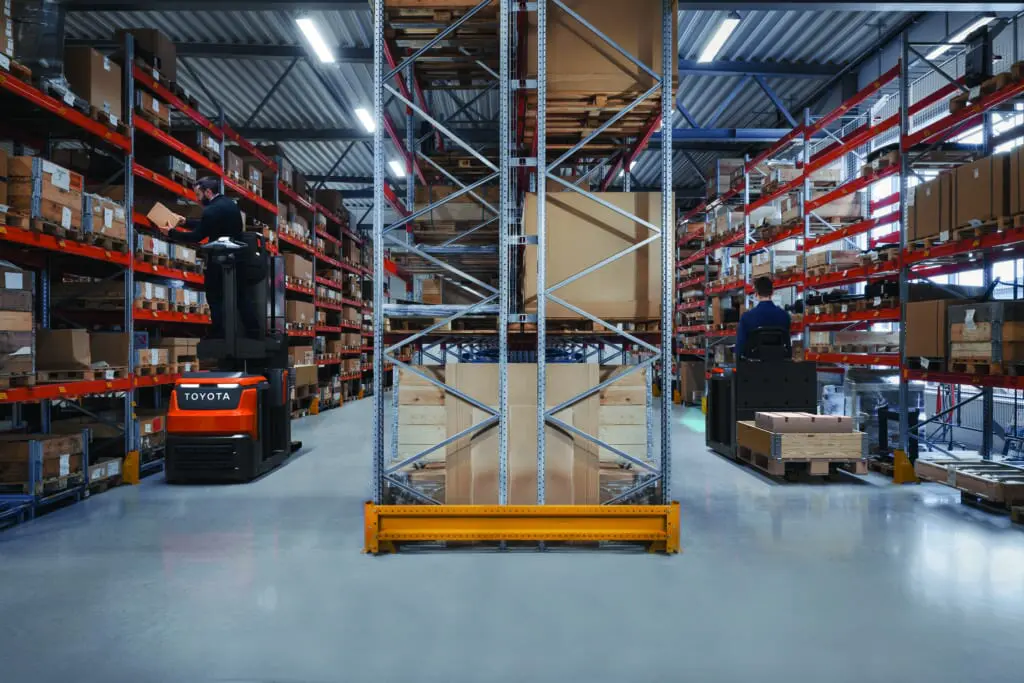 Twee magazijnmedewerkers picken orders op hoogte met Toyota BT Optio OSE120P orderpickers in magazijn met hoge stellingen | Prins Maasdijk