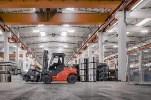 Toyota Traigo 80 elektrische heftruck met clampattachment verplaatst stalen rollen in industriële productiehal | Prins Maasdijk