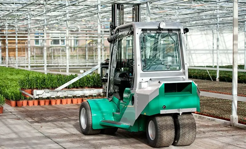 Groene Prins Tiger XXL heftruck met gesloten cabine in een kas, vooraanzicht met planten op de achtergrond. — Prins Maasdijk