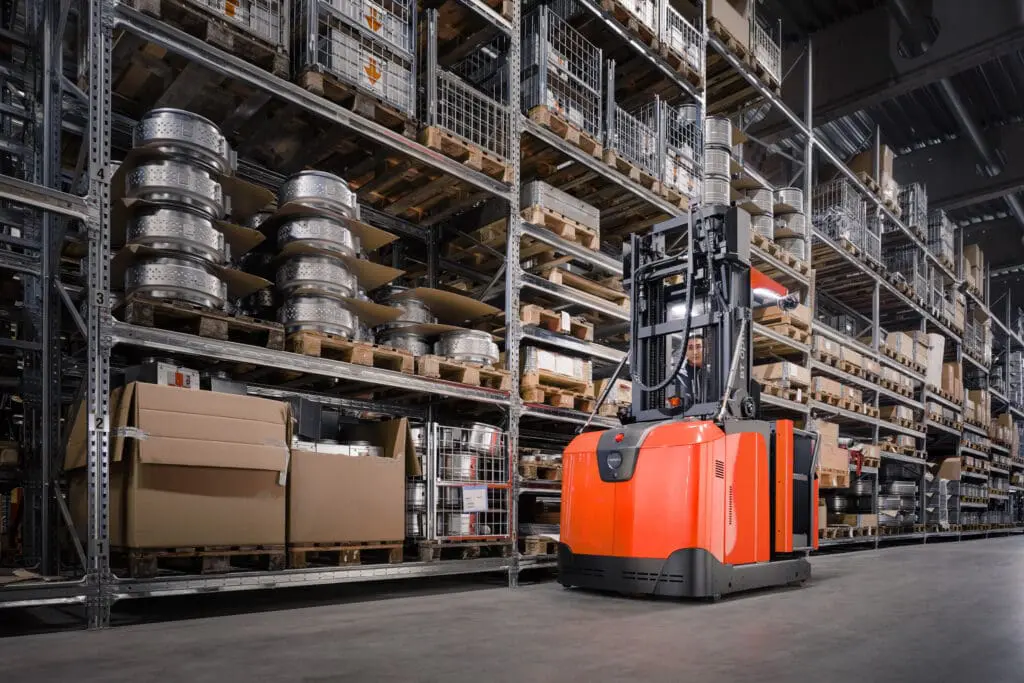 Magazijnmedewerker rijdt met Toyota BT Optio H-serie OME100H orderpicker door smal gangpad in hoog magazijn | Prins Maasdijk