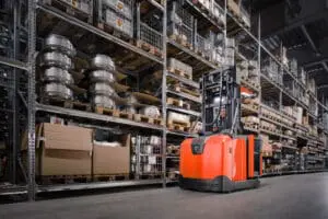 Magazijnmedewerker rijdt met Toyota BT Optio H-serie OME100H orderpicker door smal gangpad in hoog magazijn | Prins Maasdijk