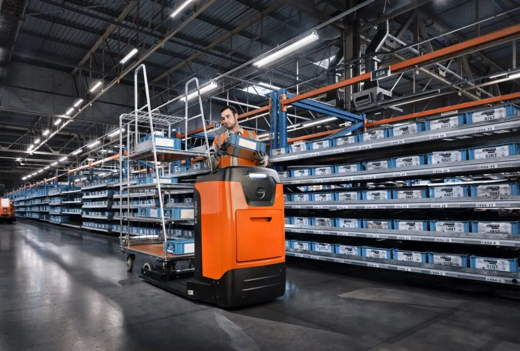 Magazijnmedewerker pickt orders met Toyota BT Optio N-serie TSE100W orderpicktruck met rolcontainer in distributiecentrum | Prins Maasdijk